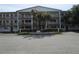 Charming condo building featuring well-maintained landscaping, an American flag, and ample parking for residents and guests at 6015 19Th N St # 301, St Petersburg, FL 33714
