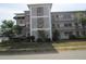 Attractive three-story condo building featuring decorative concrete block, balconies, and professional landscaping at 6015 19Th N St # 301, St Petersburg, FL 33714