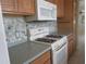 Functional kitchen featuring light wooden cabinets, modern appliances, and a tile backsplash for a clean, contemporary look at 6015 19Th N St # 301, St Petersburg, FL 33714