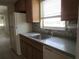 Efficient kitchen featuring wooden cabinets, a stainless-steel sink, and modern appliances with a bright window view at 6015 19Th N St # 301, St Petersburg, FL 33714