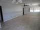 This large living room is filled with lots of light and has white tile flooring, a fan, and access to other rooms at 6015 19Th N St # 301, St Petersburg, FL 33714