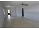A spacious living room featuring neutral-toned tiled floors, a ceiling fan, and a doorway to the kitchen at 6015 19Th N St # 301, St Petersburg, FL 33714