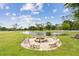 Inviting backyard with a stone fire pit and views of the pond, creating a perfect setting for gatherings and outdoor relaxation at 6080 Taneytown St, North Port, FL 34291