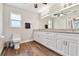 Bathroom featuring wood floors, white vanity, granite countertops, and large mirror at 6080 Taneytown St, North Port, FL 34291