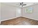 Bright bedroom featuring wood floors, a ceiling fan, and a window with plantation shutters at 6080 Taneytown St, North Port, FL 34291