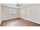 Bedroom featuring wood floors, a ceiling fan, and a window with plantation shutters at 6080 Taneytown St, North Port, FL 34291