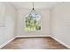 Bright dining area featuring wood floors, neutral walls, large window with backyard view and modern lighting fixture at 6080 Taneytown St, North Port, FL 34291