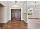 Inviting entryway with wood floors, double doors, transom window, and modern lighting fixture at 6080 Taneytown St, North Port, FL 34291