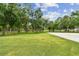 Expansive front yard with mature trees and lush green grass, creating a serene setting at 6080 Taneytown St, North Port, FL 34291