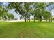 Manicured front yard with grass, trees and large circular driveway to the home at 6080 Taneytown St, North Port, FL 34291