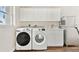 Laundry room featuring modern washer, dryer and sink with white cabinetry at 6080 Taneytown St, North Port, FL 34291