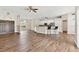 Expansive open-concept living room boasts wood floors, access to dining area, and neutral paint scheme at 6080 Taneytown St, North Port, FL 34291