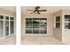 Patio with a ceiling fan overlooking the screened pool, doors and stone floors at 6080 Taneytown St, North Port, FL 34291