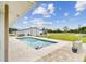 Inviting swimming pool and stone patio with view of the large barn and the lush green property at 6080 Taneytown St, North Port, FL 34291