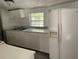 Bright kitchen featuring white cabinets, dual stainless steel sinks, and a modern refrigerator at 6201 N 38Th St, Tampa, FL 33610