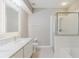 Bright bathroom featuring a white vanity, marble countertop, large mirror, and glass-enclosed shower at 6260 Olivedale Dr, Riverview, FL 33578