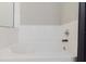 Close up on a bathtub with white tile, modern fixtures, and a gray shower curtain at 6260 Olivedale Dr, Riverview, FL 33578