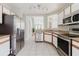 Modern kitchen with stainless steel refrigerator, appliances, and white cabinets at 6260 Olivedale Dr, Riverview, FL 33578