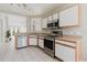 Well-lit kitchen with stainless steel appliances and view into the open-concept living area at 6260 Olivedale Dr, Riverview, FL 33578