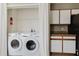 Well-equipped laundry room featuring a washer, dryer, and storage cabinets at 6260 Olivedale Dr, Riverview, FL 33578