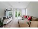 Bright living area with hardwood floors, large windows, and a modern television at 6260 Olivedale Dr, Riverview, FL 33578