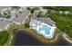 Aerial view of community pool with lounge chairs, lake, and ample parking at 6260 Olivedale Dr, Riverview, FL 33578