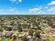 Aerial shot of neighborhood showcasing houses with lush, mature trees, under a blue sky filled with light, white clouds at 6365 32Nd N Ave, St Petersburg, FL 33710