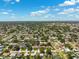 Drone eye view showcasing a neighborhood with mature trees and well maintained lawns, under a brilliant sky at 6365 32Nd N Ave, St Petersburg, FL 33710