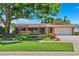 Charming single-story brick home featuring a well-manicured lawn and beautiful landscaping at 6365 32Nd N Ave, St Petersburg, FL 33710