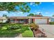 Charming single-story brick home featuring a well-manicured lawn and beautiful landscaping at 6365 32Nd N Ave, St Petersburg, FL 33710