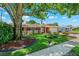Single-story home boasts lovely landscaping, including flower beds and a mature shade tree at 6365 32Nd N Ave, St Petersburg, FL 33710