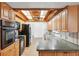 Charming kitchen with wood cabinets, black appliances, and unique wood-beam ceiling at 6365 32Nd N Ave, St Petersburg, FL 33710