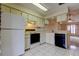 Tile kitchen featuring white appliances with a view to the living area at 6428 Gloria Dr # 21, New Port Richey, FL 34653