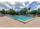 Community pool featuring clear water, lounge chairs, and mature trees at 6428 Gloria Dr # 21, New Port Richey, FL 34653