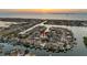 Aerial view showcasing a waterfront home with a boat dock and sunset in the background at 6604 Dolphin Cove Dr, Apollo Beach, FL 33572