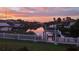 Waterfront view of grassy yard with a white fence, boat dock, and stunning sunset reflections at 6604 Dolphin Cove Dr, Apollo Beach, FL 33572