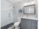 Modern bathroom features a sleek glass shower, gray vanity with quartz countertop, and stylish fixtures and mirror at 6604 Dolphin Cove Dr, Apollo Beach, FL 33572