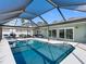 Relaxing pool view showcasing the covered outdoor seating and tranquil waterfront location of this home at 6604 Dolphin Cove Dr, Apollo Beach, FL 33572
