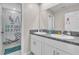 Bathroom featuring granite counters, double sinks, white cabinets, and shower with a unicorn curtain at 6653 Mineral Springs Rd, New Port Richey, FL 34653