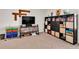 Carpeted bonus room offering a comfortable entertainment area with a large shelving unit at 6653 Mineral Springs Rd, New Port Richey, FL 34653