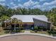 Exterior view of community center featuring a stone facade, manicured landscaping, and palm trees at 6653 Mineral Springs Rd, New Port Richey, FL 34653