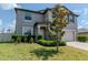 Charming two-story home with a well-maintained lawn and landscaping, including a young tree and trimmed shrubs at 6653 Mineral Springs Rd, New Port Richey, FL 34653