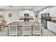 Well-equipped kitchen island with sink, seating, and granite countertops, complemented by white cabinetry at 6653 Mineral Springs Rd, New Port Richey, FL 34653