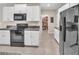 Functional kitchen layout featuring stainless steel appliances, white cabinets, and granite countertops at 6653 Mineral Springs Rd, New Port Richey, FL 34653