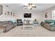 Inviting living room featuring tile floors, plush sofas, a ceiling fan, and a large wall-mounted television at 6653 Mineral Springs Rd, New Port Richey, FL 34653