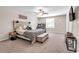 This carpeted bedroom includes a ceiling fan, tv, and a desk in front of the window at 6653 Mineral Springs Rd, New Port Richey, FL 34653