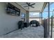 Covered outdoor entertainment area with TV, grill, and ceiling fan at 6653 Mineral Springs Rd, New Port Richey, FL 34653