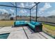 Screened-in patio with comfortable black wicker furniture and bright blue cushions at 6653 Mineral Springs Rd, New Port Richey, FL 34653
