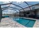 Backyard pool and hot tub with full screen enclosure, lounge furniture and entertainment area at 6653 Mineral Springs Rd, New Port Richey, FL 34653