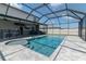 Inviting backyard pool with surrounding gray pavers and full screen enclosure at 6653 Mineral Springs Rd, New Port Richey, FL 34653